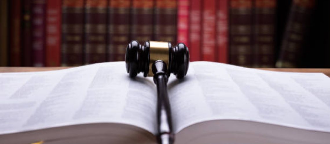 Close-up Of An Open Law Book And Wooden Mallet In Courtroom